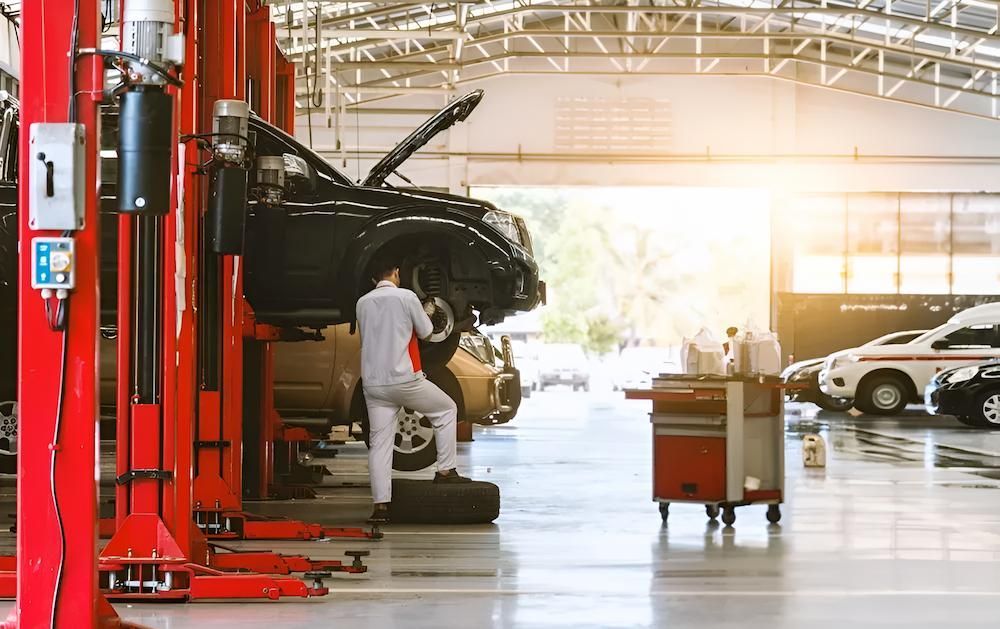 A Man is Working on a Car in a Garage — Docs Mobile Tyre Service In Yandina, QLD