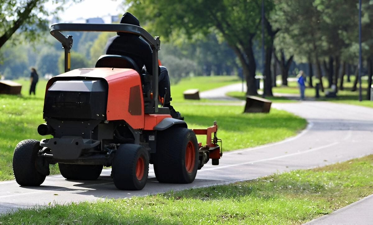 A Person is Riding a Lawn Mower Down a Path — Docs Mobile Tyre Service In Kawana, QLD