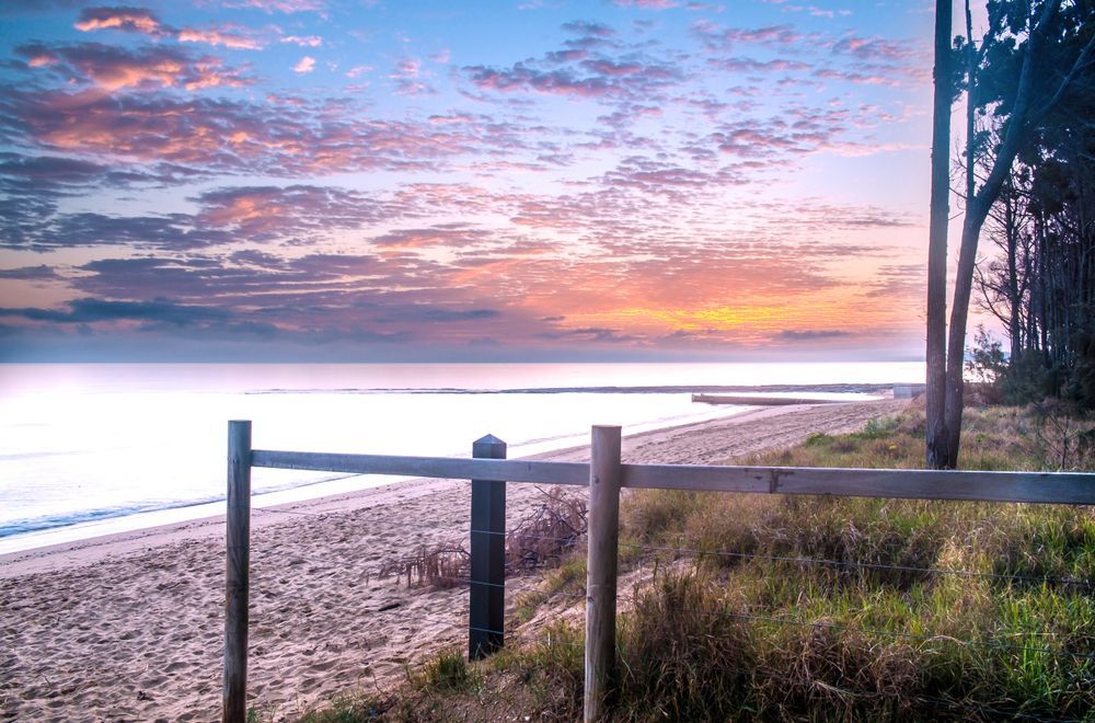 Sunset Over a Calm Beach With a Wooden Fence — Docs Mobile Tyre Service In Pialba, QLD