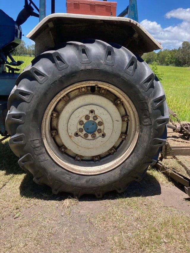 A Tractor With a Large Tire is Parked in a Field — Docs Mobile Tyre Service In Buderim, QLD