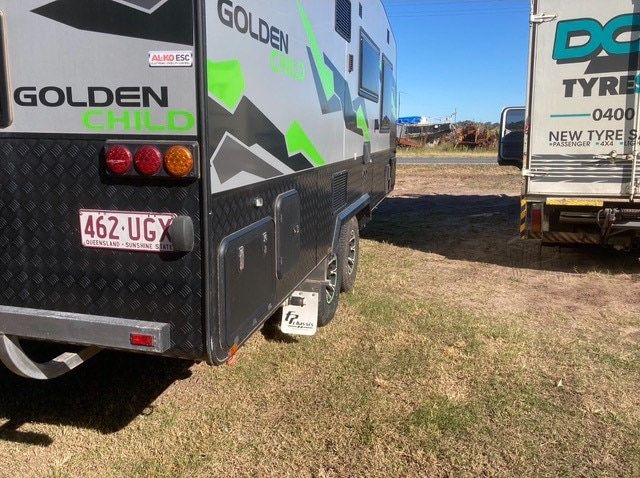 A Caravan Is Parked In A Grassy Field — Docs Mobile Tyre Service in Hervey Bay, QLD
