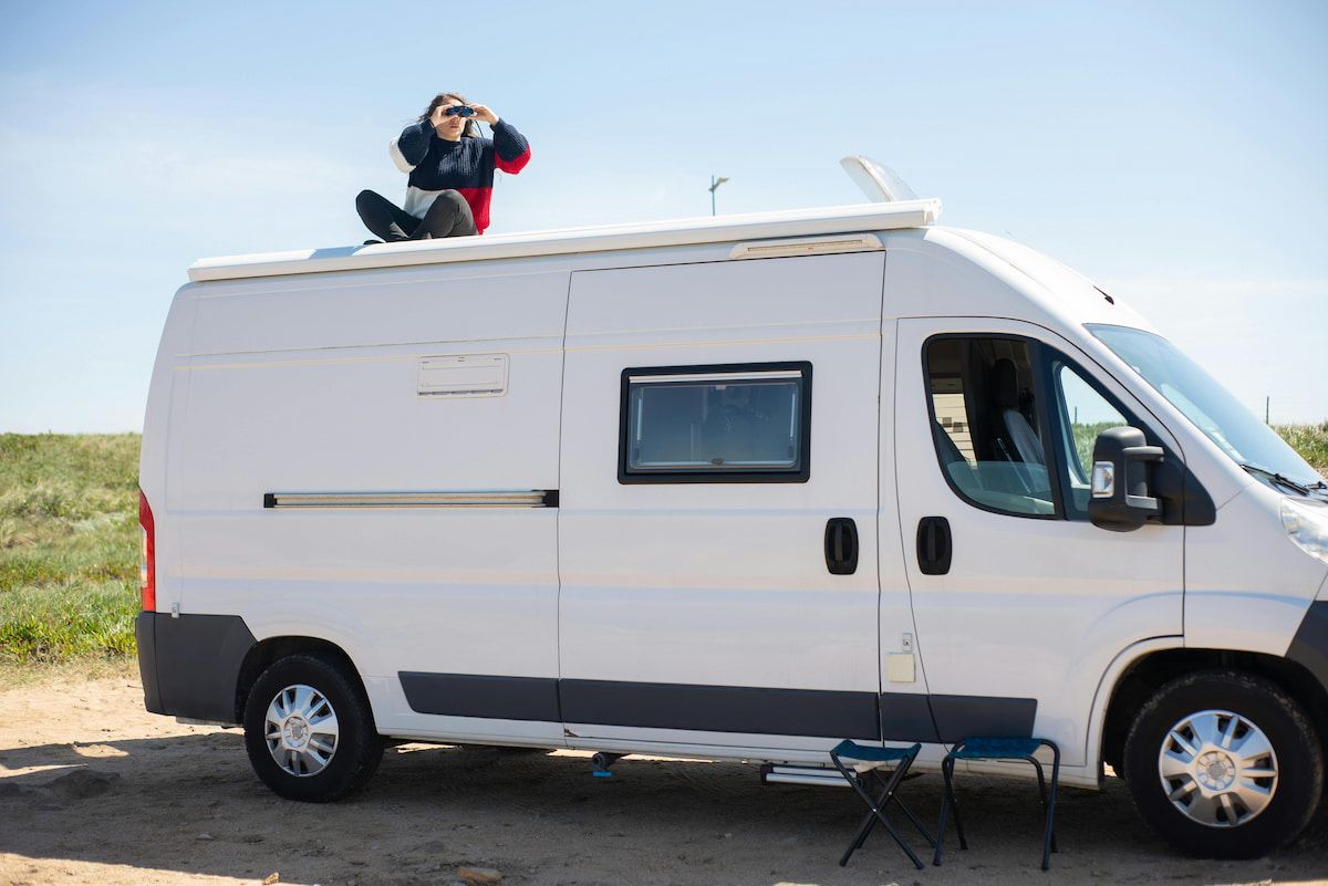 A Man Is Sitting on Top of A White Van — Docs Mobile Tyre Service in Hervey Bay, QLD