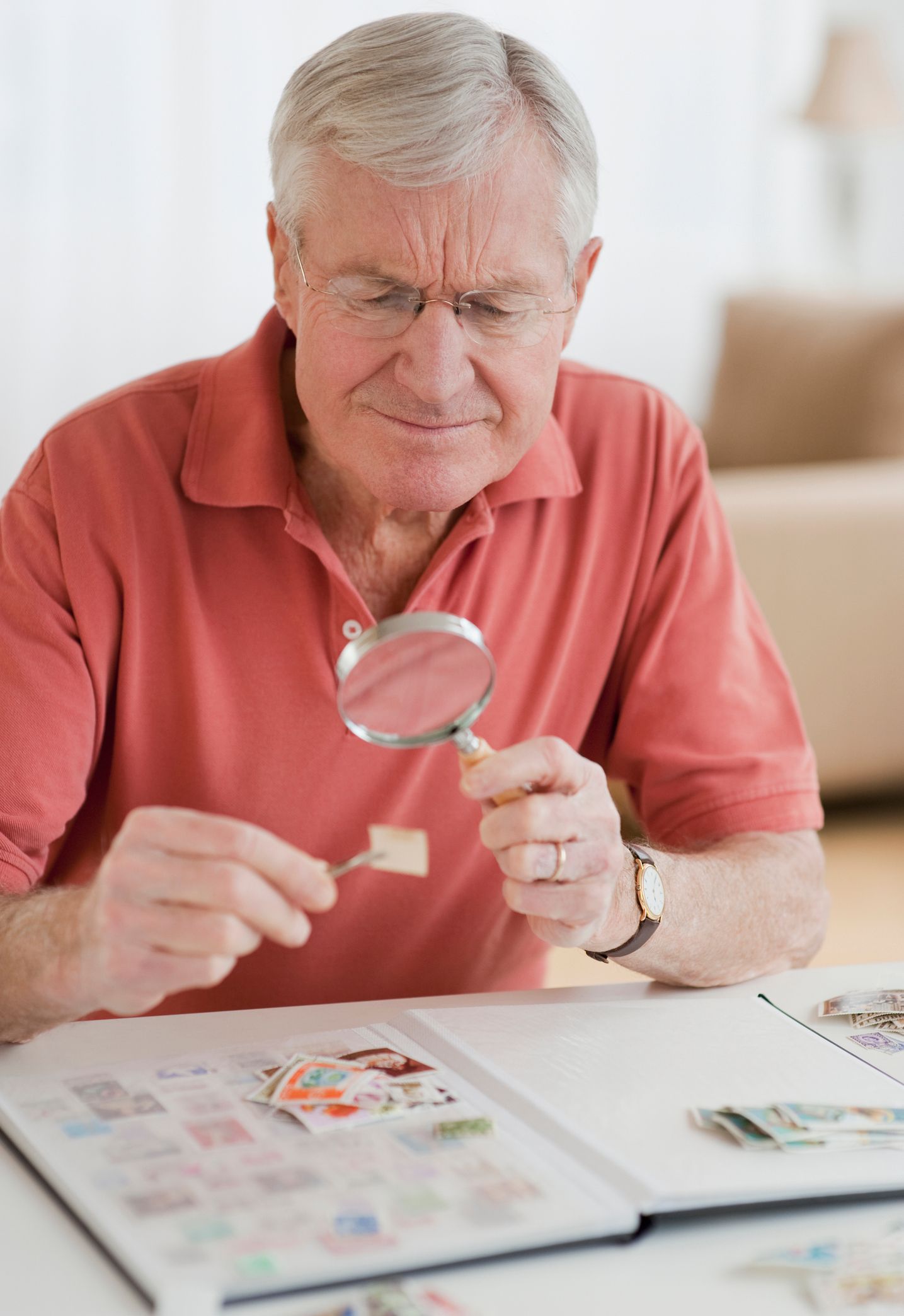 Elderly Man Looking For Stamp Through A Magnifying Glass — Hills, MI — BC Coins and Stamps 