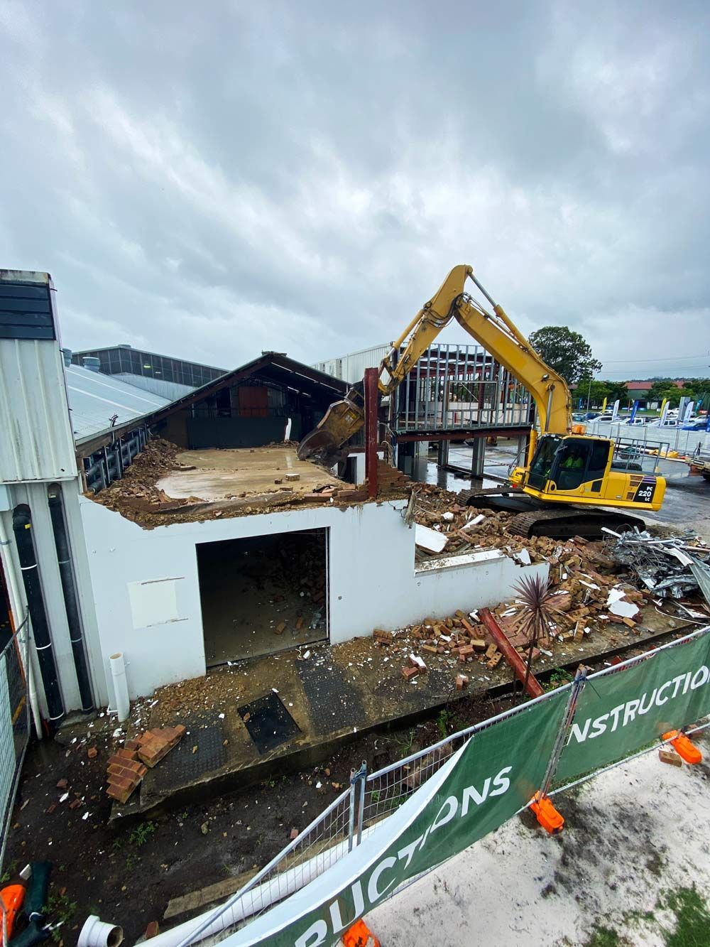 A Large Yellow Excavator Is Demolishing A Building — Ballina Demolitions In Tweed Heads, NSW