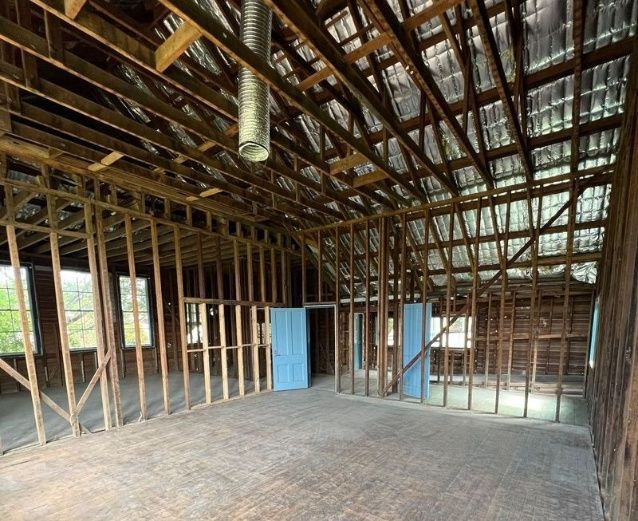 A Large Empty Room With Wooden Beams And A Metal Roof — Ballina Demolitions In Byron Bay, NSW