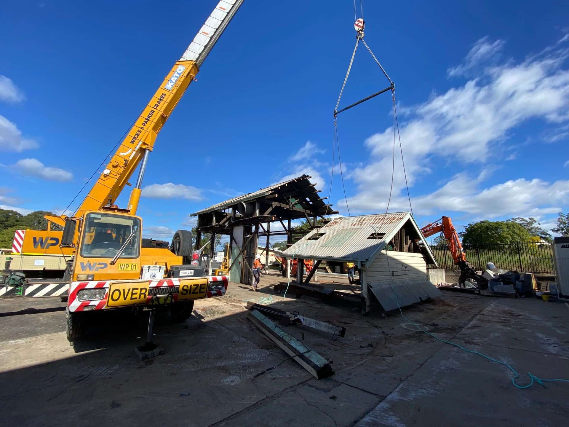 A Large Yellow Excavator Is Demolishing A Building — Ballina Demolitions In Tweed Heads, NSW