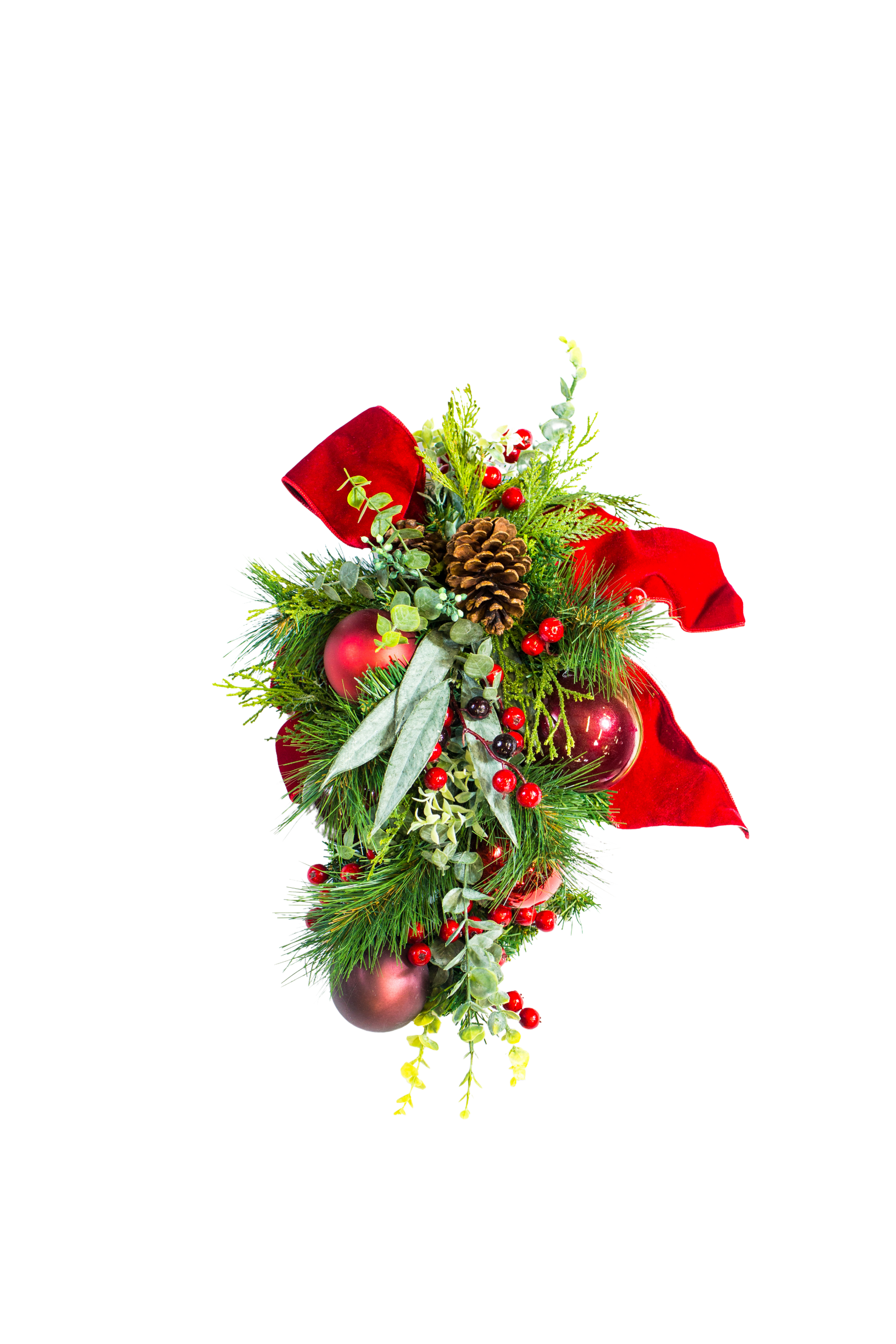Christmas swag with red bow, ornaments, pinecones, and greenery.