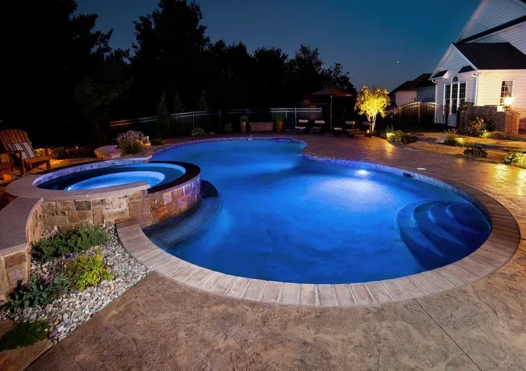 A large swimming pool is lit up at night