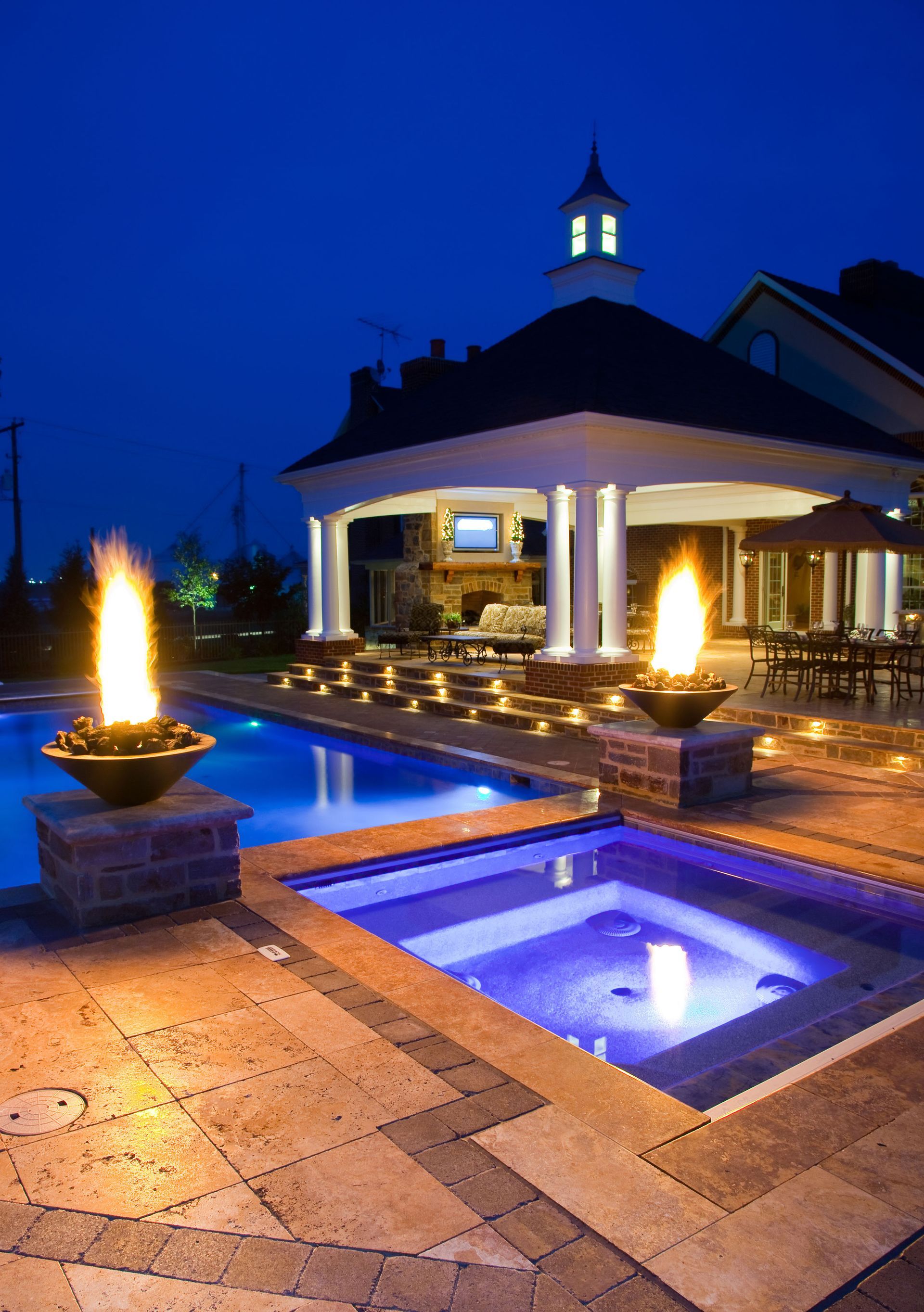 A large swimming pool with a gazebo in the background at night