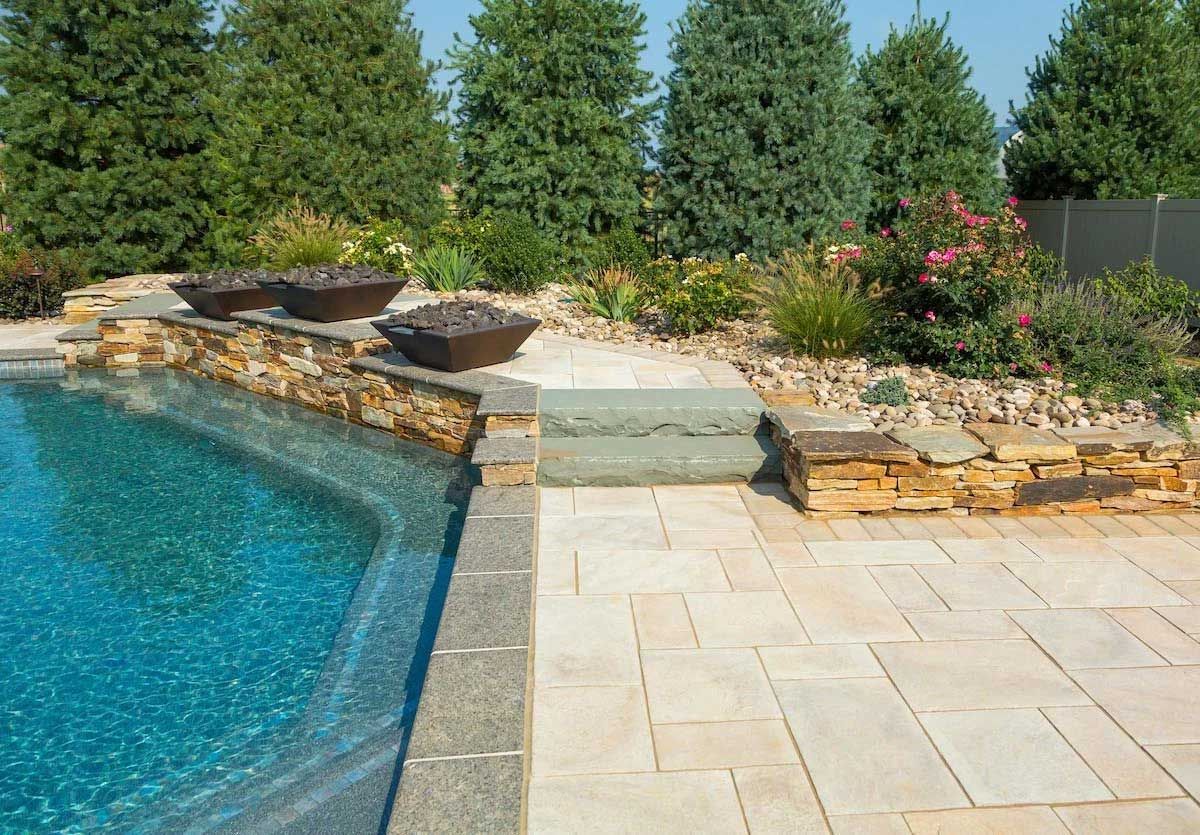 A large swimming pool surrounded by trees and a patio.