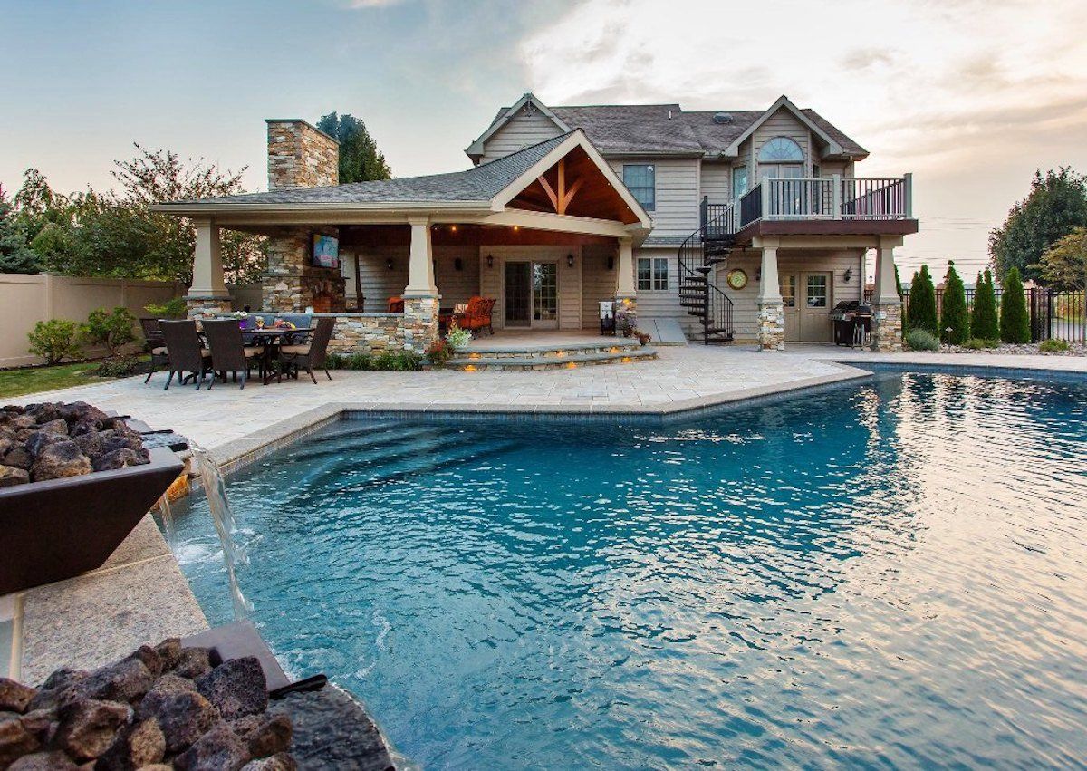 A large house with a large swimming pool in front of it.