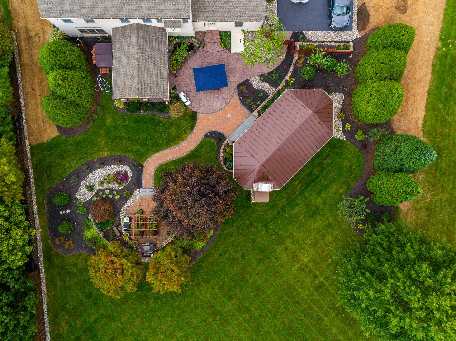 An aerial view of a house with a large lawn and a patio.