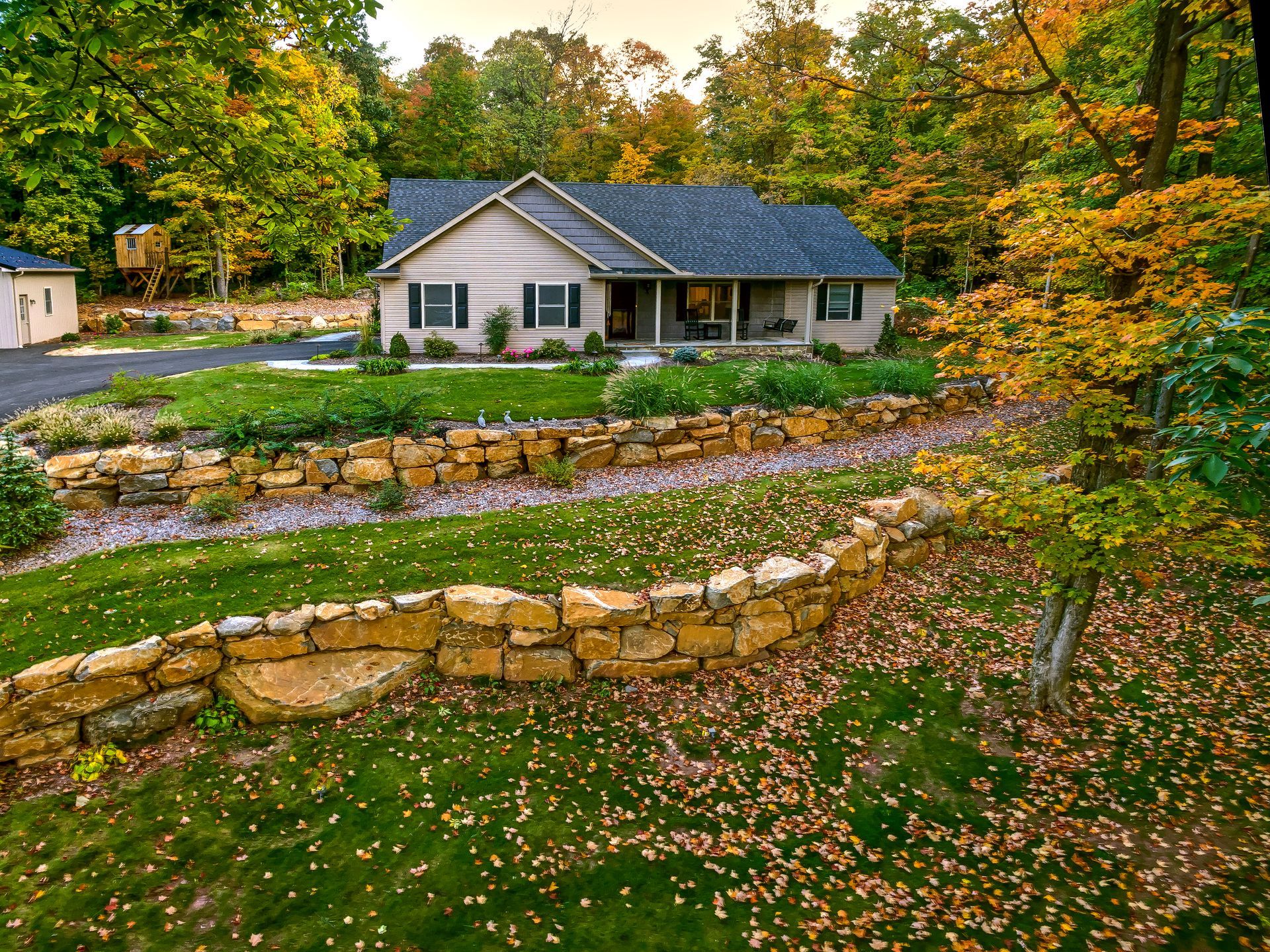 A house with a stone wall in front of it