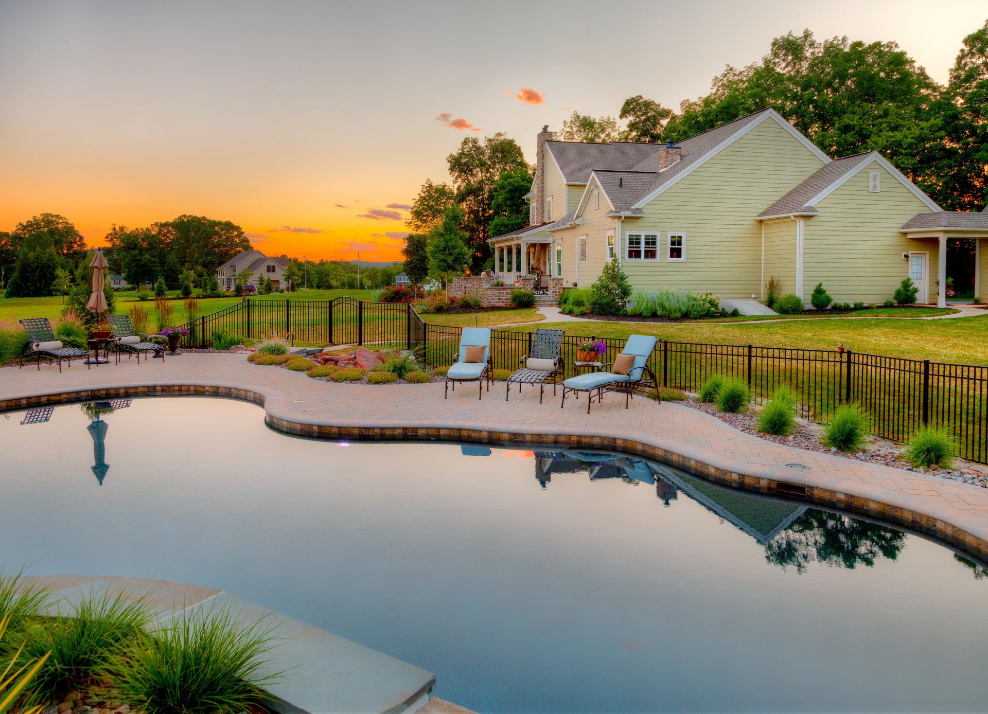 A house with a large swimming pool in front of it