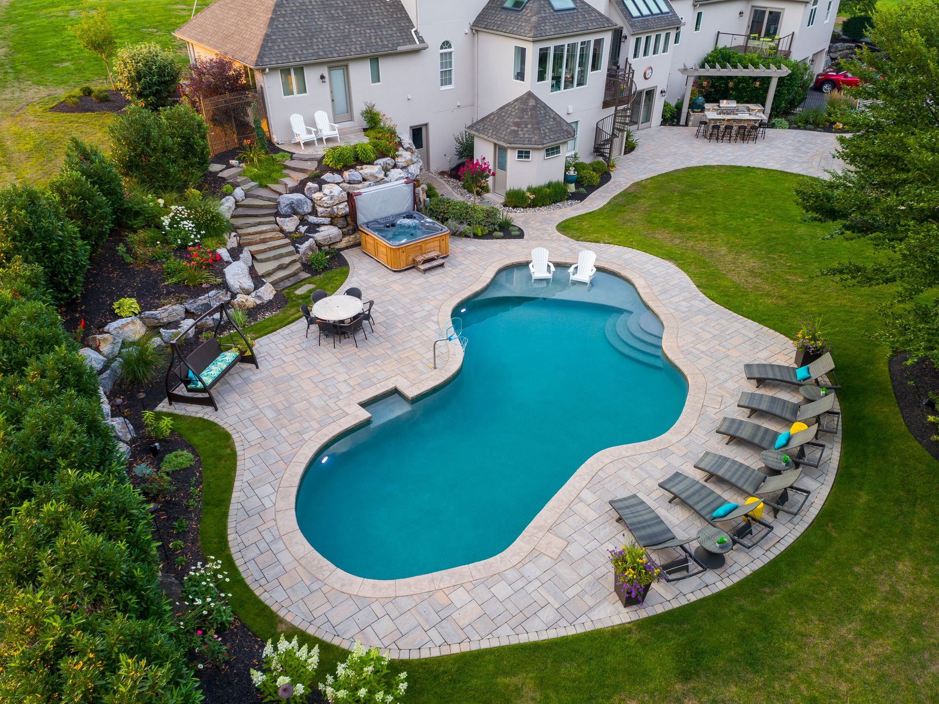 An aerial view of a large swimming pool in the backyard of a house.