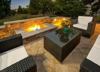 A patio with wicker furniture and a fire pit.