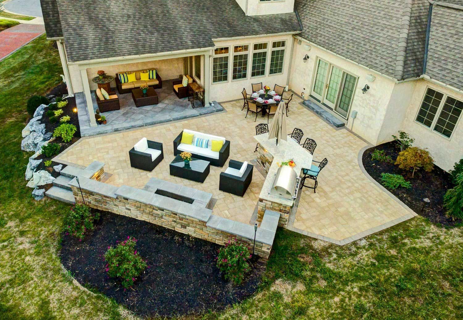 An aerial view of a large house with a patio and furniture.
