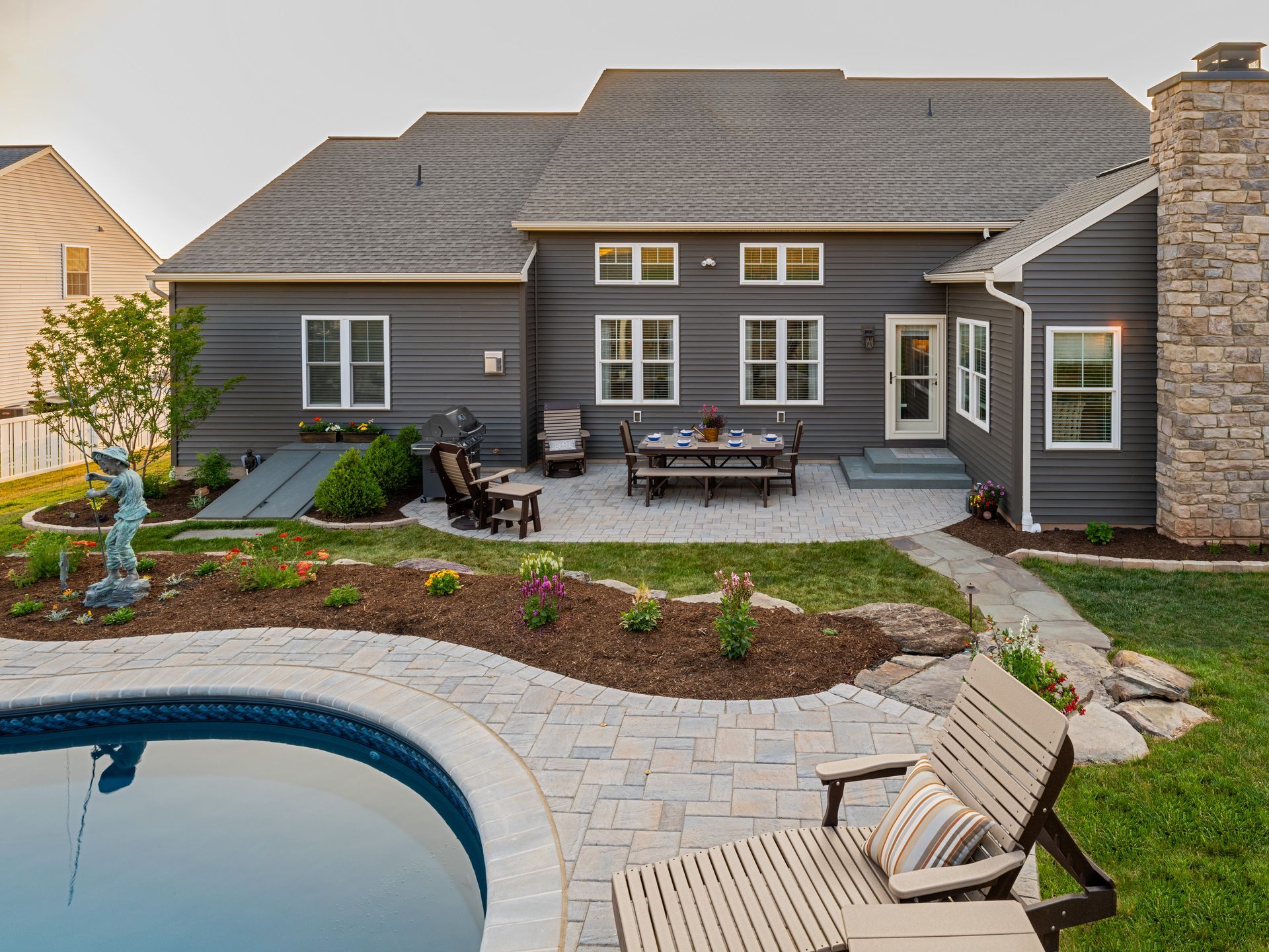 A large house with a patio and a pool in front of it.
