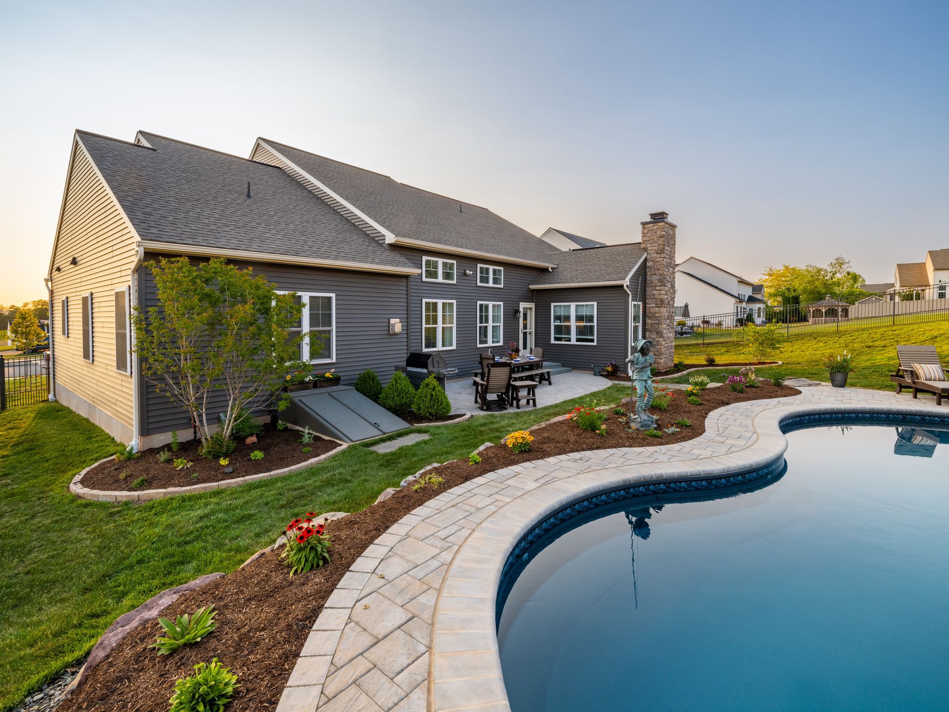 A large house with a large swimming pool in front of it.