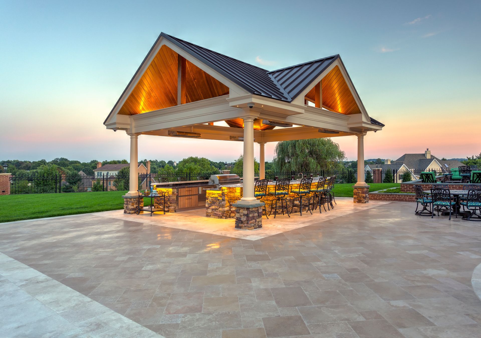 A large wooden gazebo with a roof that is lit up at night.