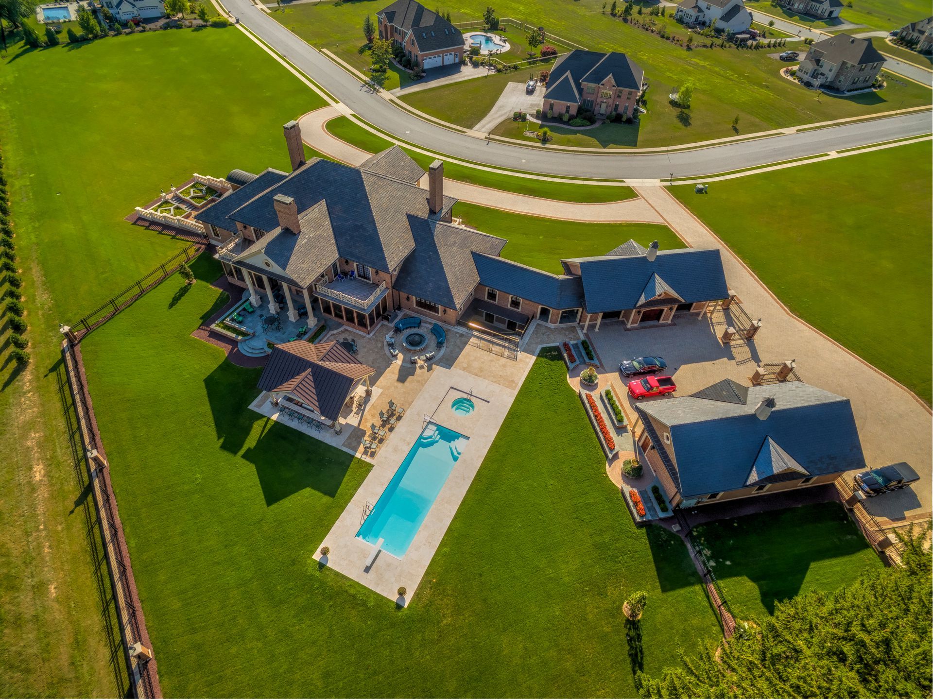 An aerial view of a large house with a pool in the backyard.