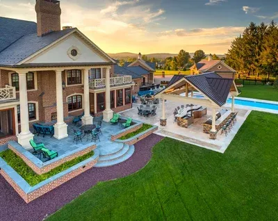 An aerial view of a large house with a pool and patio area.