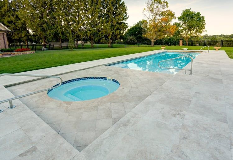 A large swimming pool with a hot tub in the middle