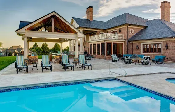 A large house with a swimming pool in front of it.