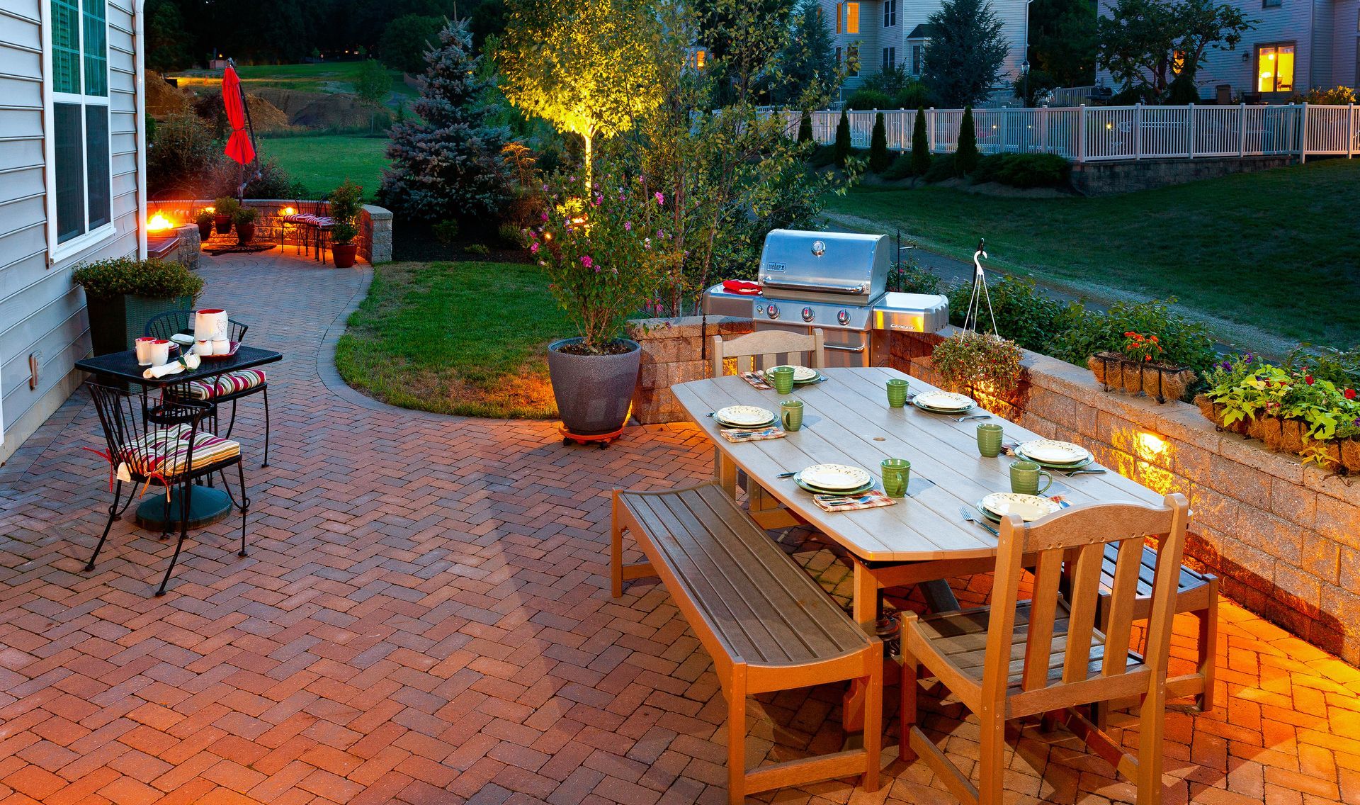 A patio with a table and chairs and a grill