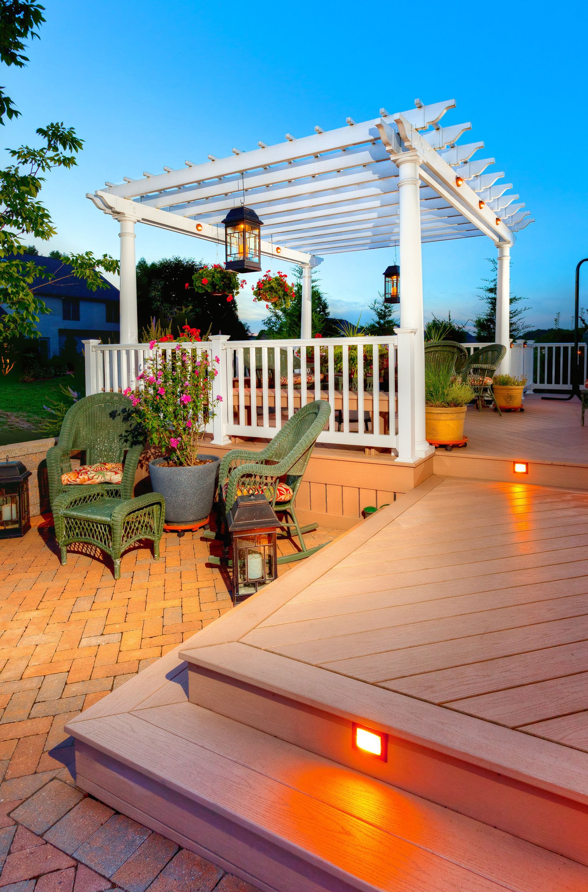 A patio with a pergola and chairs and stairs