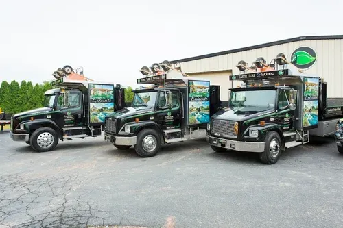 Three trucks are parked in front of a building.