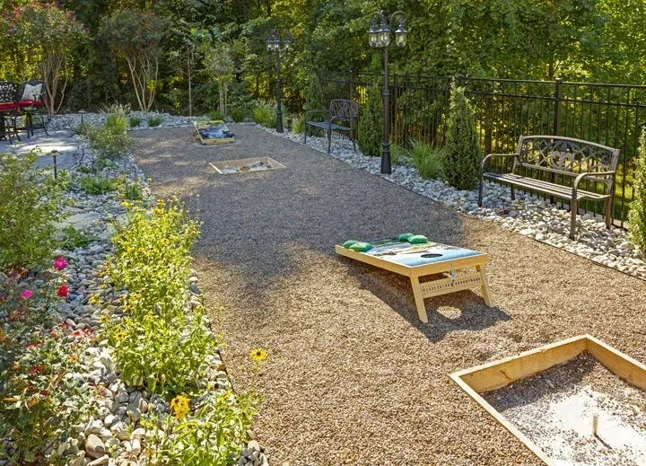 There is a cornhole board in the middle of the yard.