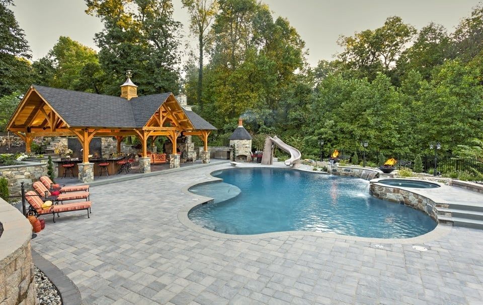 A large swimming pool with a gazebo in the background