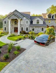 A car is parked in front of a large house.