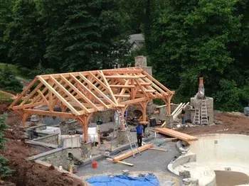 A wooden structure is being built next to a pool.