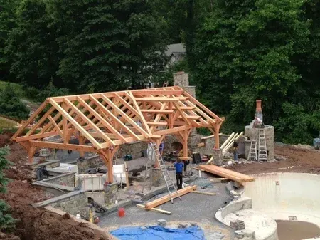 A wooden structure is being built next to a pool.