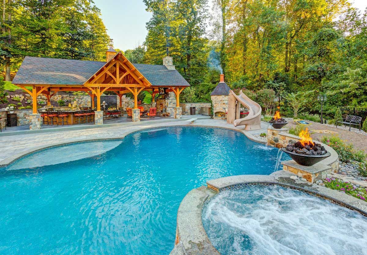 A large swimming pool with a gazebo and a fire pit in the backyard.