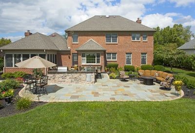A large brick house with a large patio in front of it.