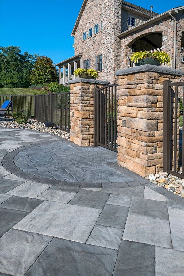 A large stone house with a patio in front of it.