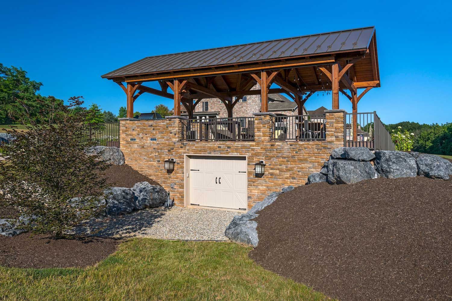 A brick building with a wooden roof and a garage underneath it.
