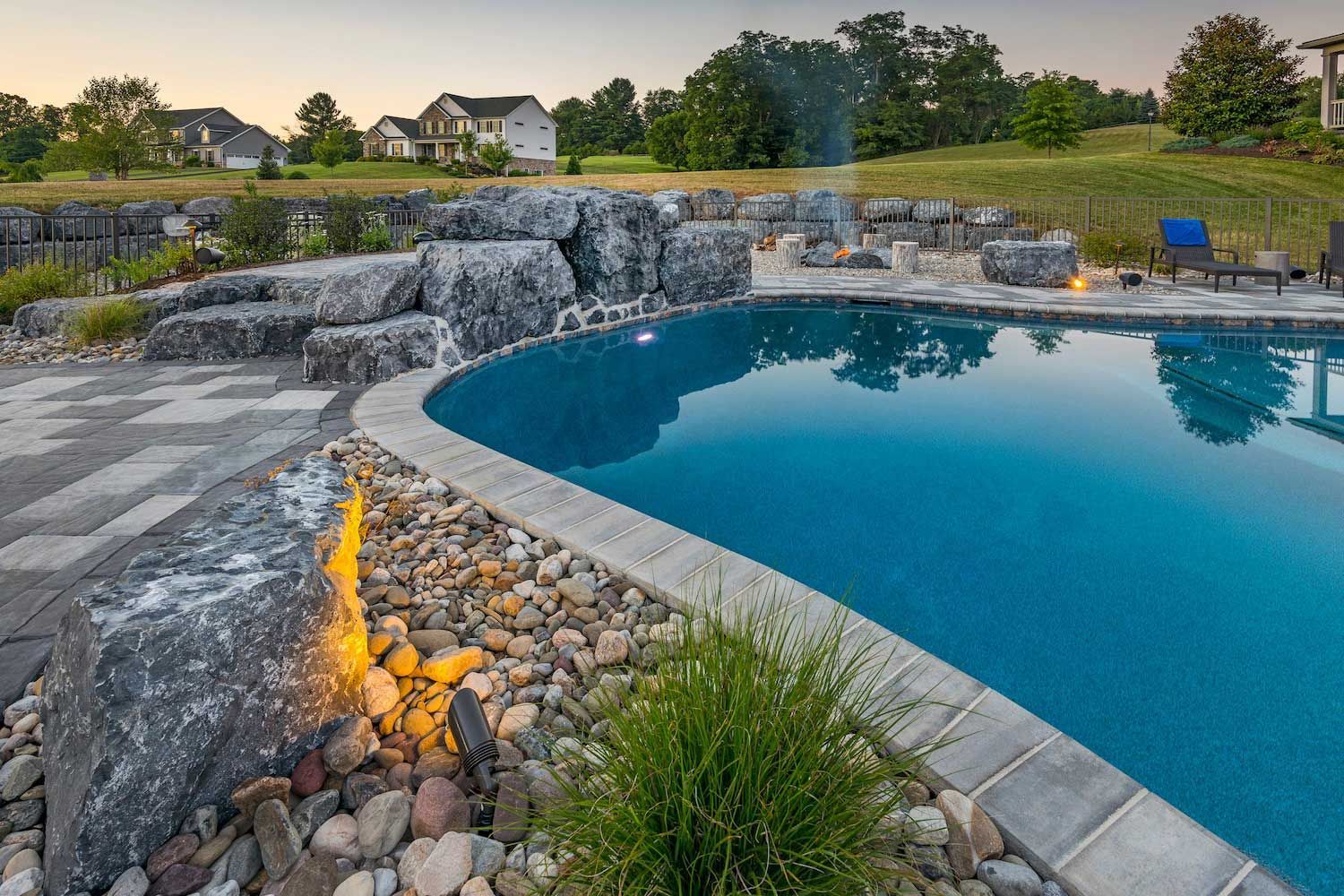 A large swimming pool with a fire pit in the middle