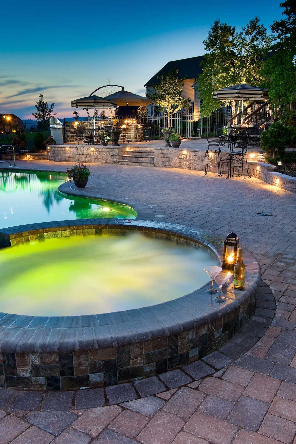 A large swimming pool with a hot tub in the middle of it