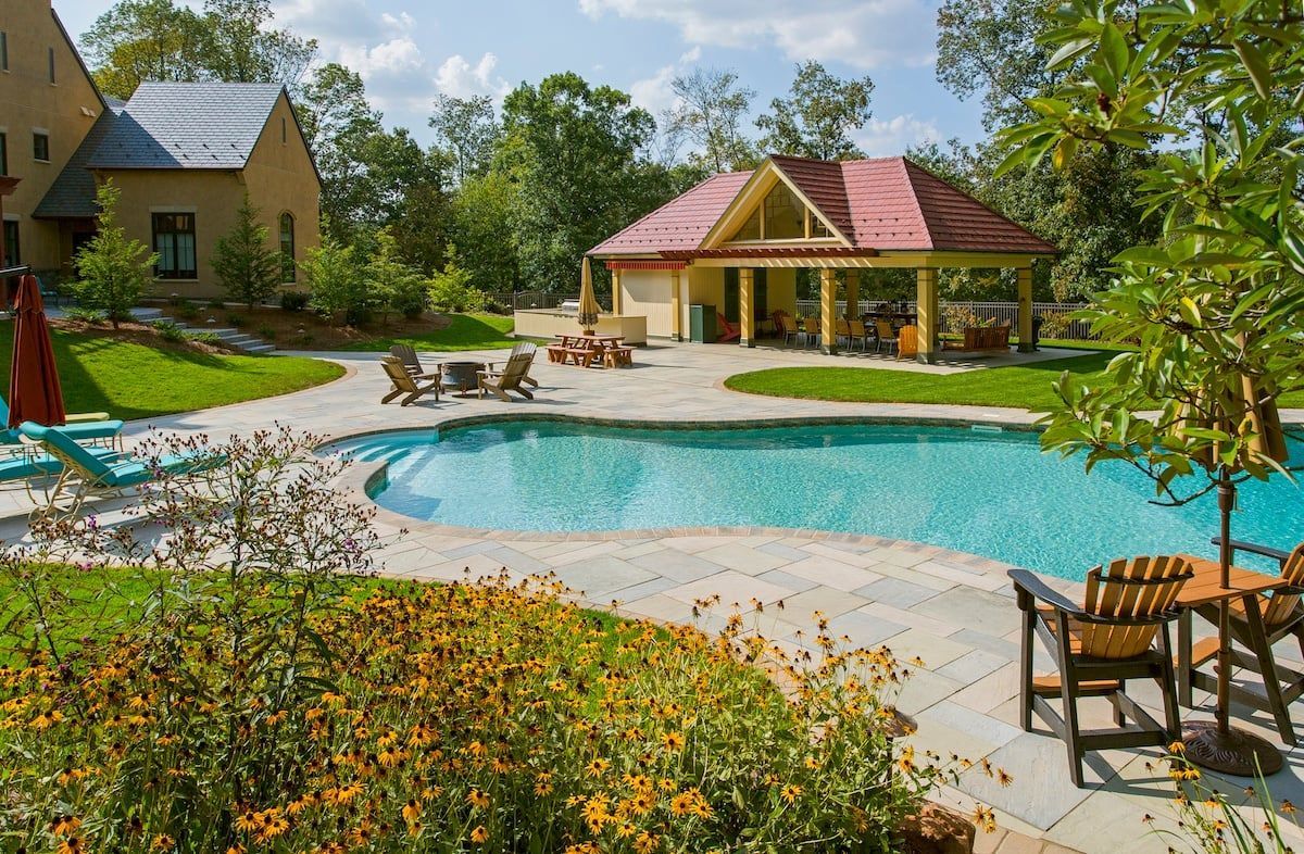 There is a large swimming pool in the backyard of a house.