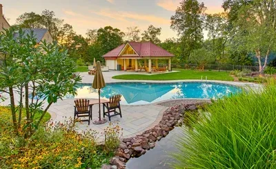 A large swimming pool with a gazebo in the background