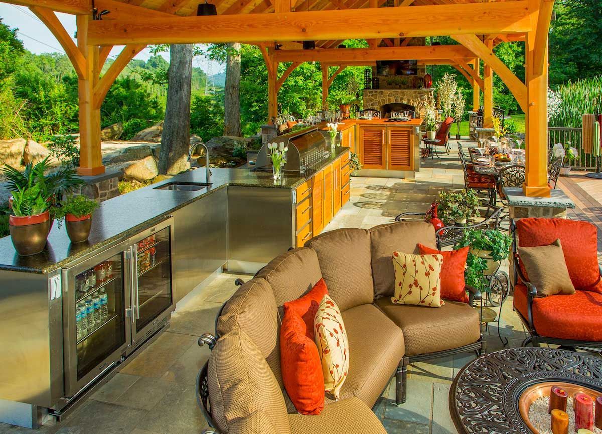 A living room with a couch and chairs under a wooden structure.