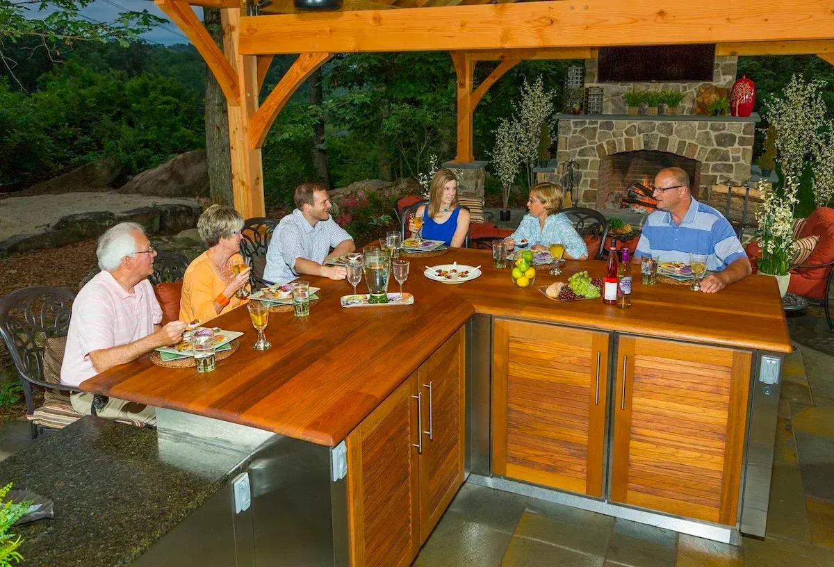 A group of people are sitting around a wooden table eating food.
