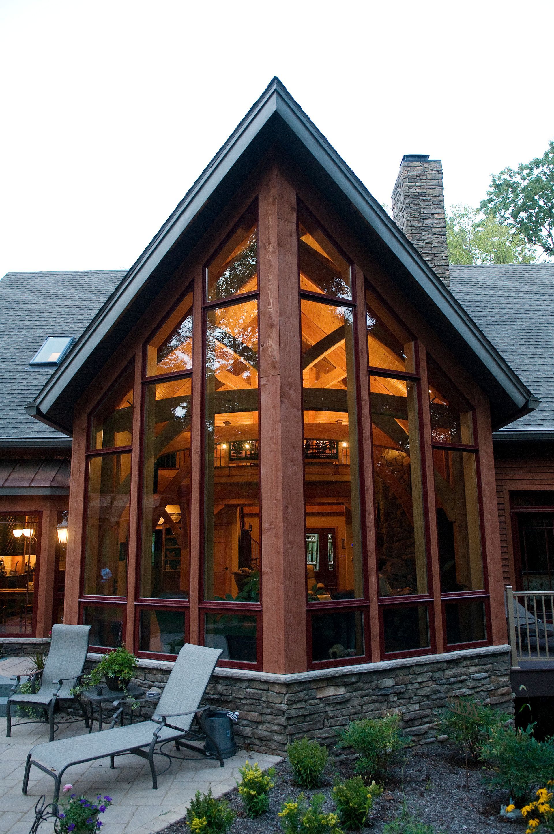 A house with a lot of windows and chairs outside