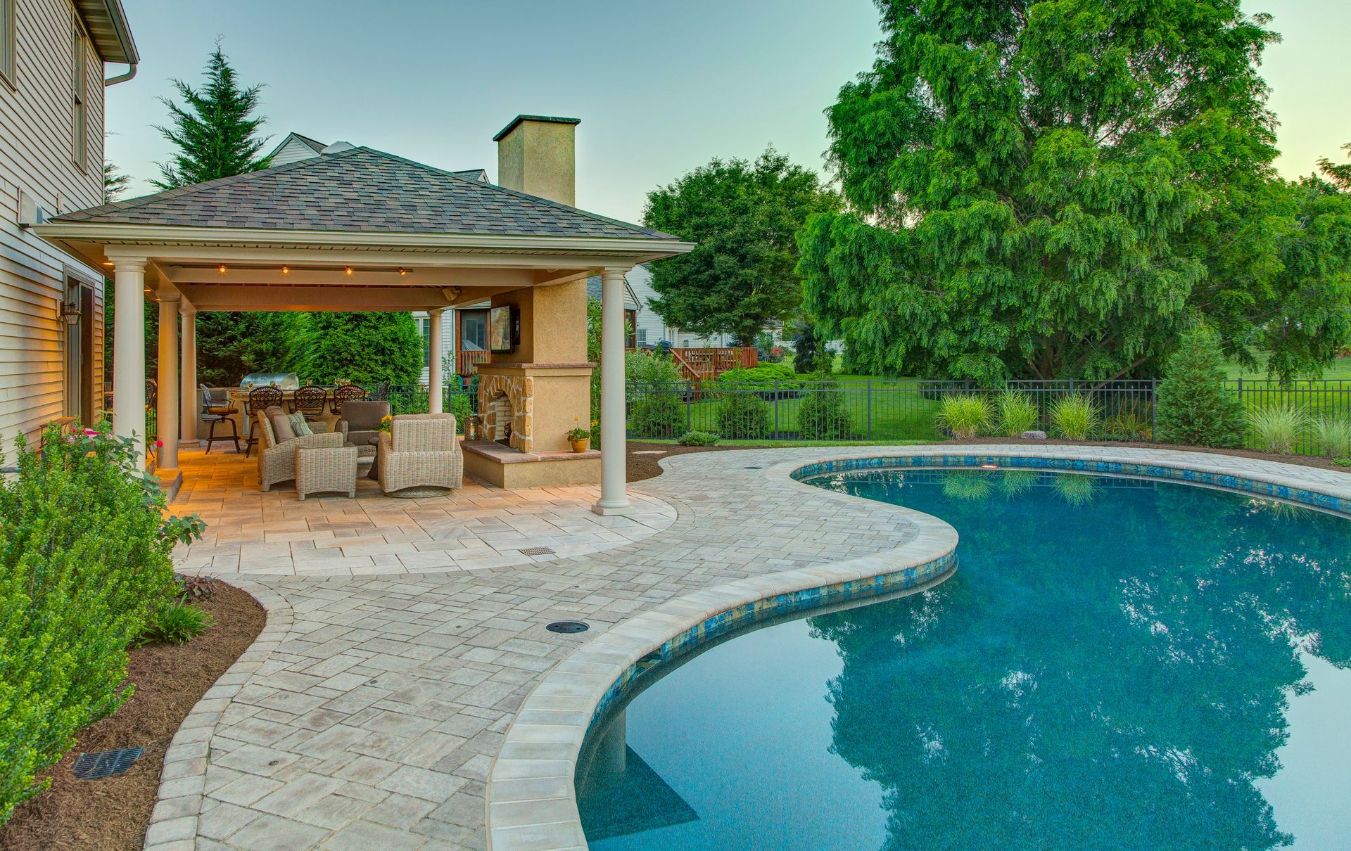 A large swimming pool with a pavilion in the backyard