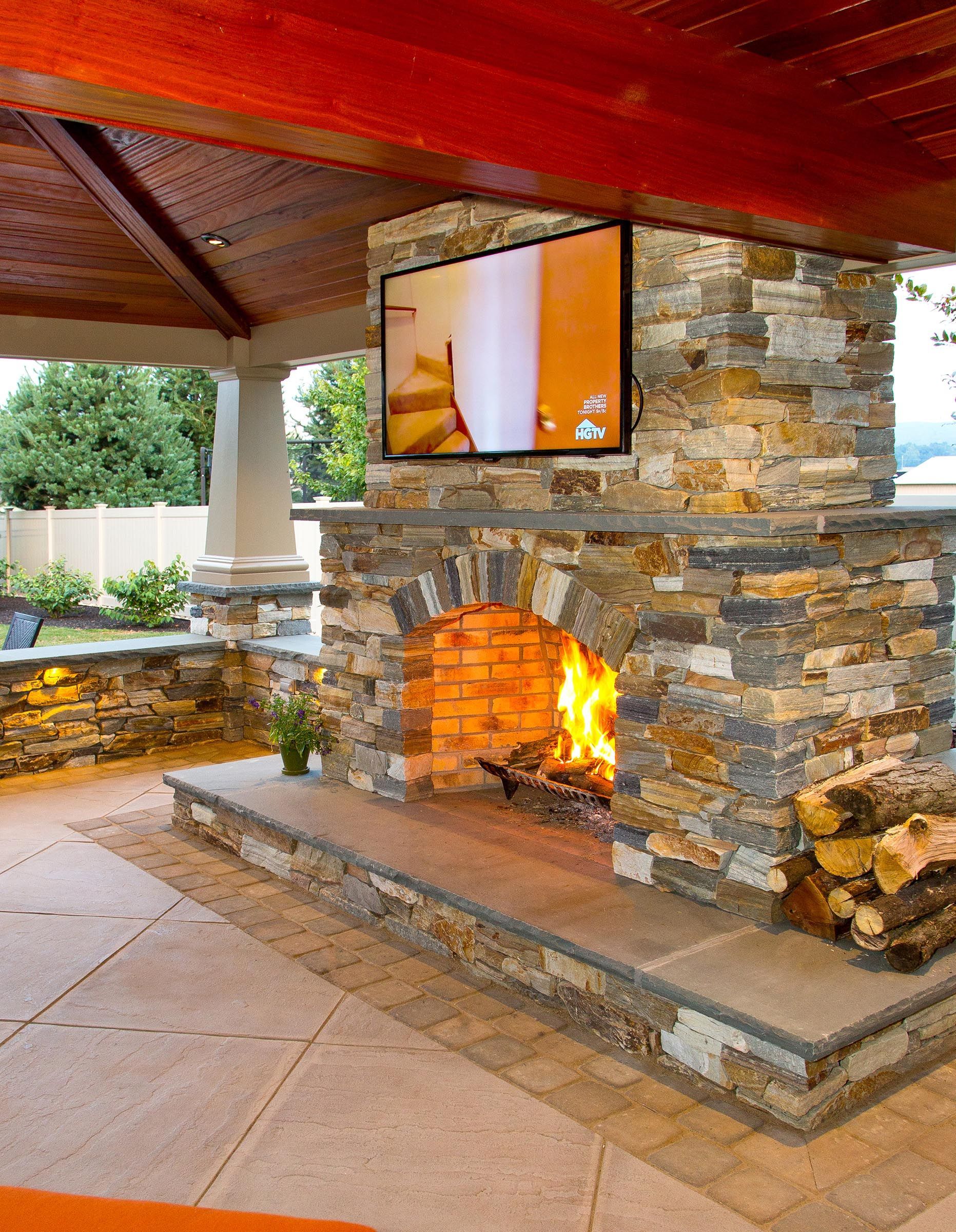 A stone fireplace with a flat screen tv above it