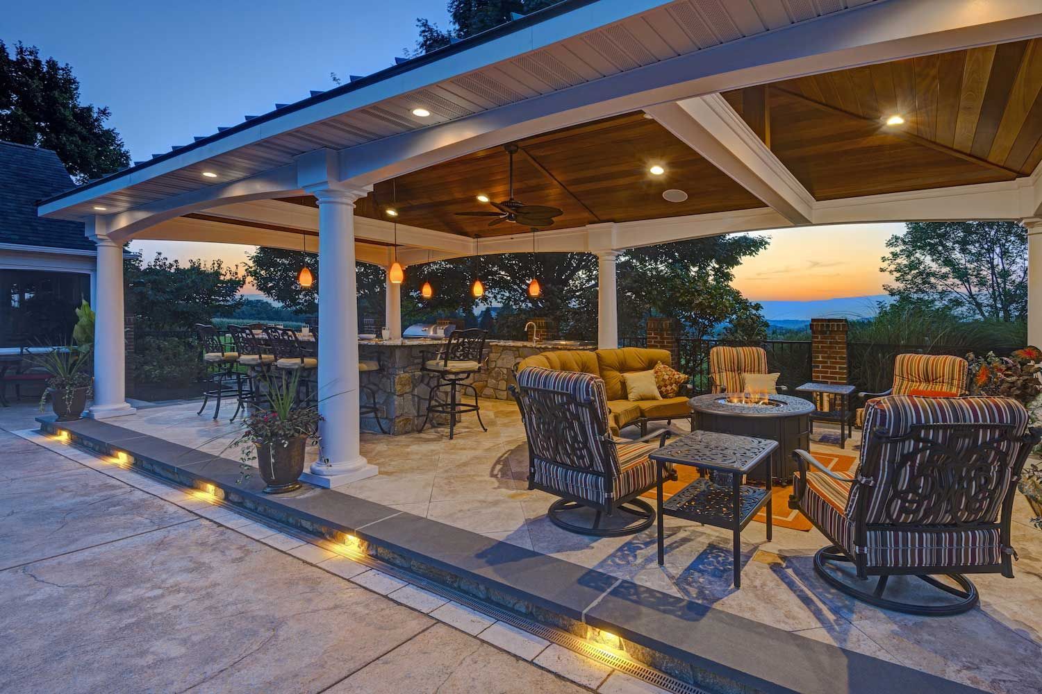 A patio with a table and chairs on it in front of a house.